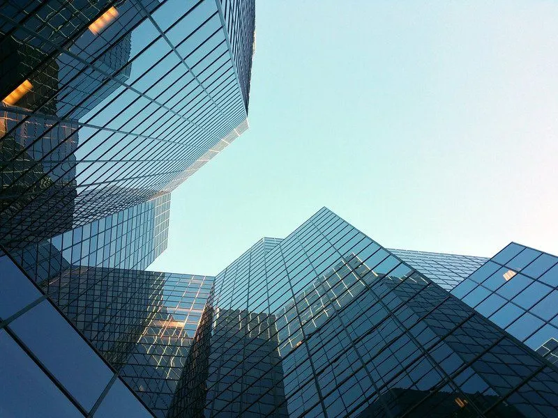 Glass office towers rising against a clear blue sky